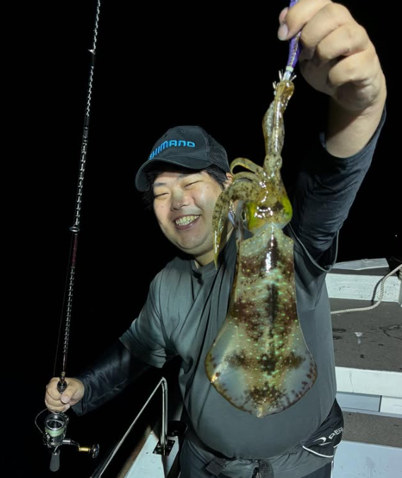 鳥取でのティップランエギングの釣果。シマノのキャップを被ったお客様が、良型のアオリイカを手に満面の笑み。