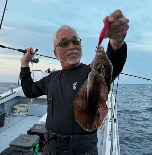 鳥取のティップランでアオリイカを釣り上げた重見プロ。ピンク色のエギでヒットさせた一杯を手に、さすがのテクニックを披露。