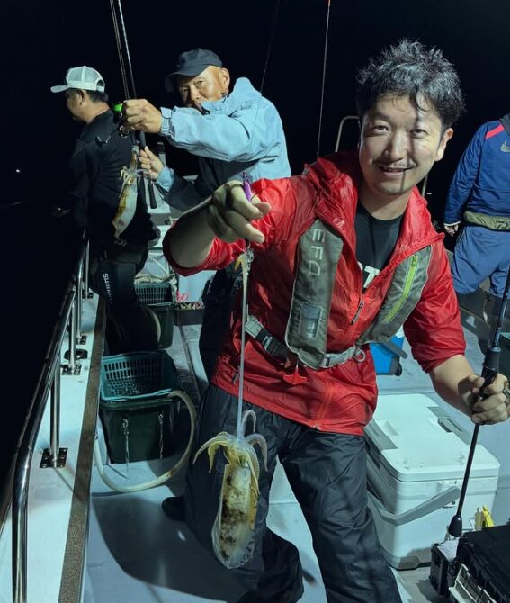 鳥取のティップランでアオリイカがダブルヒット！船上が盛り上がる中、お客様が笑顔で釣果を見せている。
