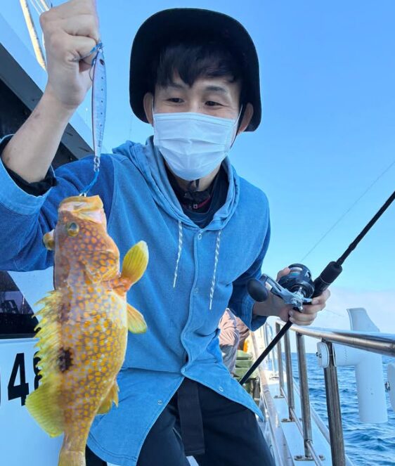 鳥取のジギングで、本命の根魚をキャッチ！青いウェアを着たお客様が、価値ある一匹を手に記念撮影。