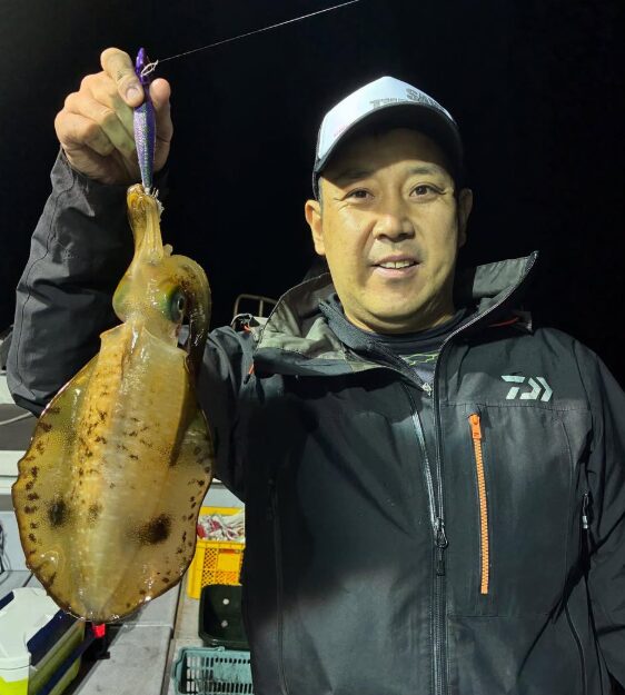 新晴丸のティップランでアオリイカをキャッチ！鳥取の夜の海で、お客様が嬉しい釣果を手に満面の笑み。