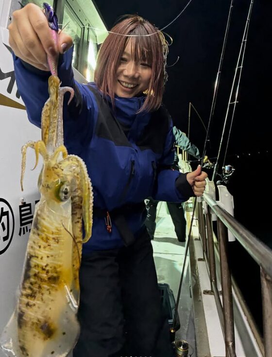 鳥取でのティップラン釣行。女性アングラーが釣り上げたアオリイカを手に、最高の笑顔でピースサイン。