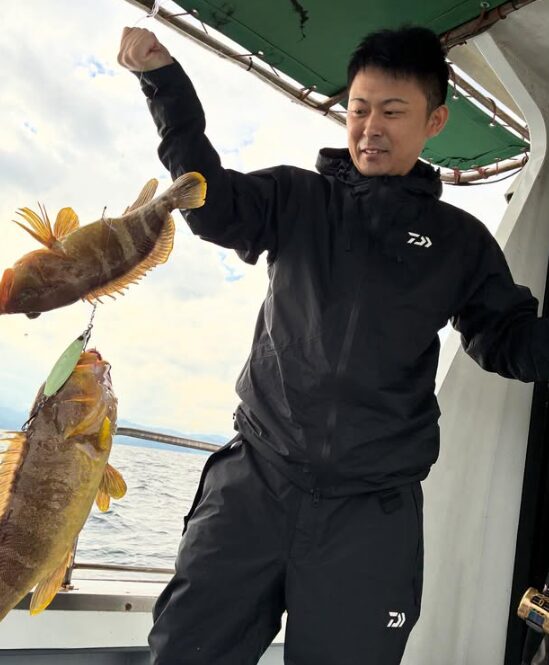 鳥取の遊漁船「新晴丸」でのジギング釣果。お客様が、連なったアオハタを手に満足げな表情。