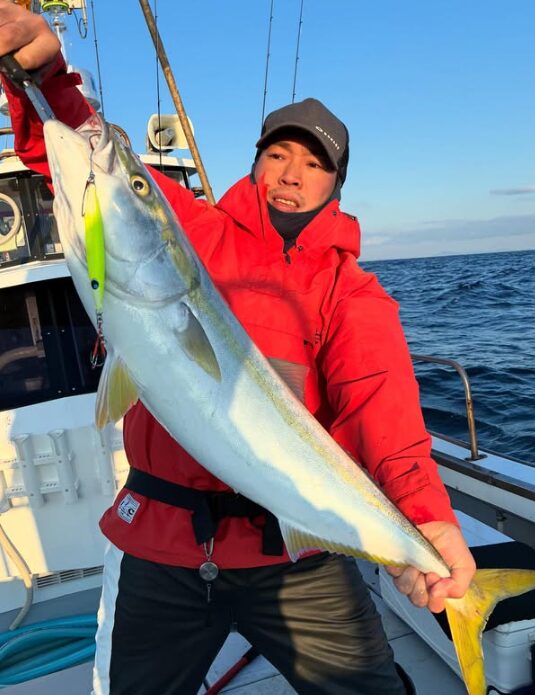 山陰（鳥取）のジギングで釣り上げた見事な青物（ハマチ）。お客様が、嬉しい釣果を手に記念撮影。