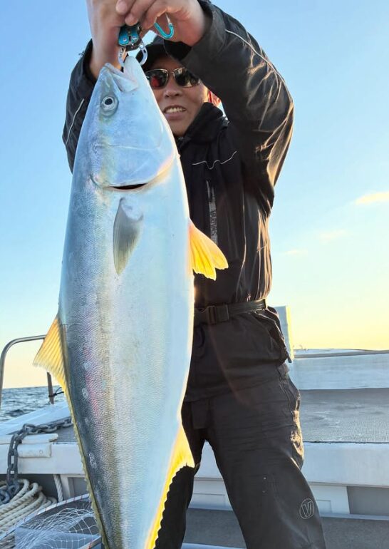 山陰（鳥取）のジギングで釣り上げた立派な青物。お客様が、嬉しい釣果を高々と掲げる。