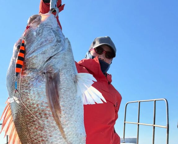 山陰（鳥取）のジギングで釣り上げた見事な青物（ハマチ）。お客様が、嬉しい釣果を手に記念撮影。