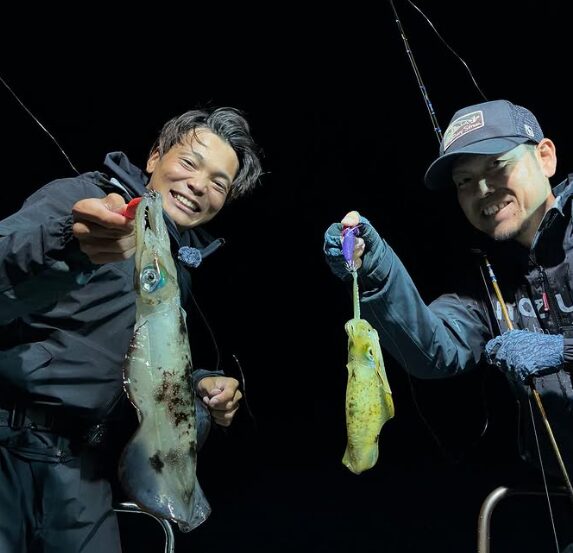 鳥取の釣り船にて、夜のティップランを楽しむお客様。釣果のアオリイカを二人で仲良く手に持ち、笑顔で記念撮影。