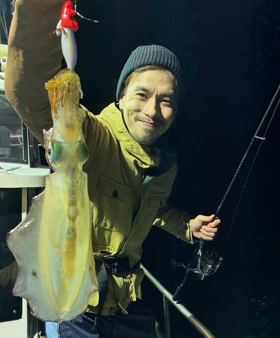 新晴丸の鳥取ティップランで釣り上げたアオリイカ。ニット帽を被ったお客様が、厳しい中での貴重な釣果を手に笑顔。