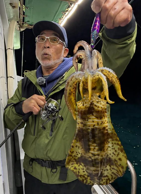 鳥取の釣り船を利用し、ティップランで良型のアオリイカを釣り上げたお客様。驚いたような表情で釣果を披露する様子。