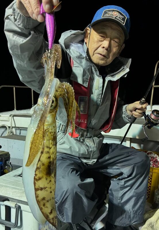 鳥取のアオリイカティップランで、紫系のエギを使い良型のアオリイカを釣り上げた、赤いライフジャケットのお客様