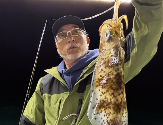 鳥取の遊漁船にて、ティップランでアオリイカを釣り上げた重見プロ。釣果をカメラに向かって見せる様子。