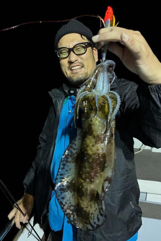 鳥取でのティップランで釣り上げたアオリイカ。波風が強い中での貴重な釣果を手に、お客様が笑顔で記念撮影。