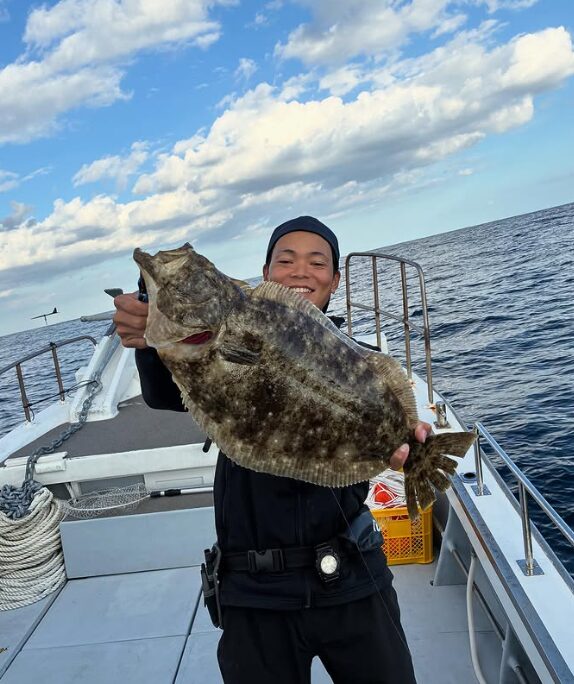 鳥取のジギングで釣り上げた、見事な座布団ヒラメを船上で披露するお客様。